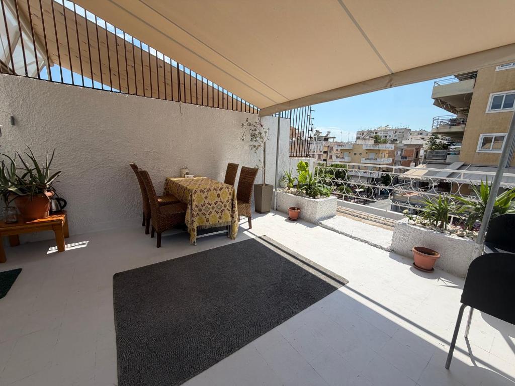 a patio with a table and chairs on a balcony at Piraeus Sea Loft in Piraeus