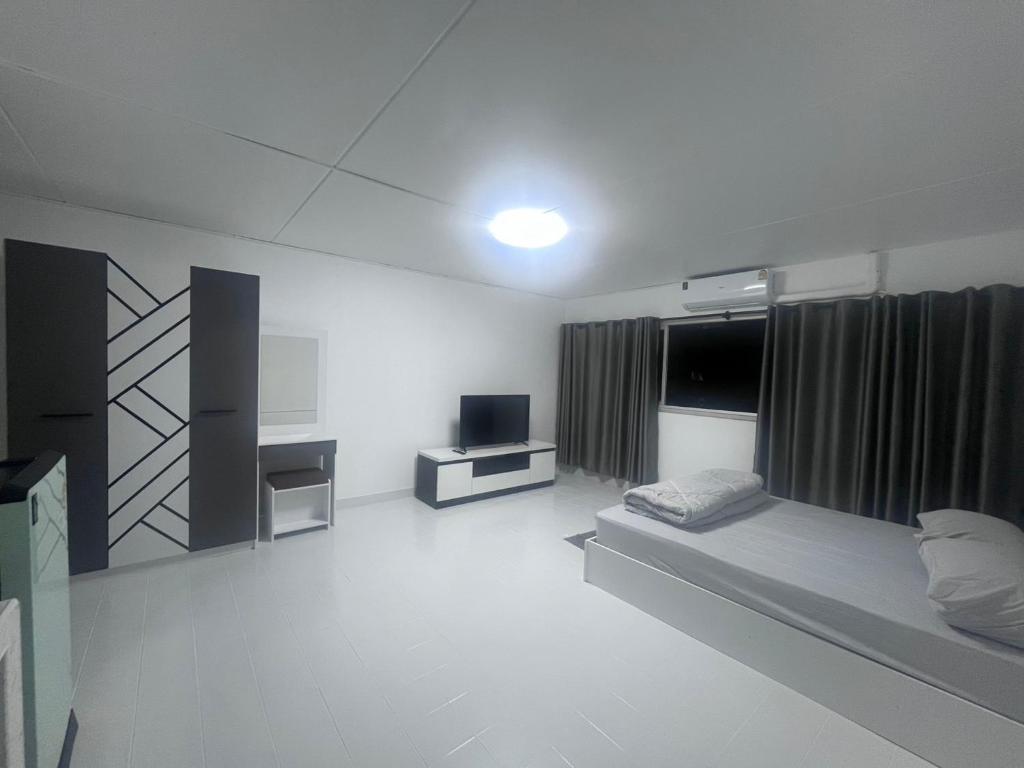 a white room with a bed and a tv at อิมแพค เมืองทองธานี c8 ชั้น 13 ห้องพักรายวัน in Thung Si Kan