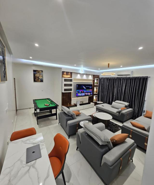 a living room with couches and a pool table at NewAge Smart 2 in Ikeja