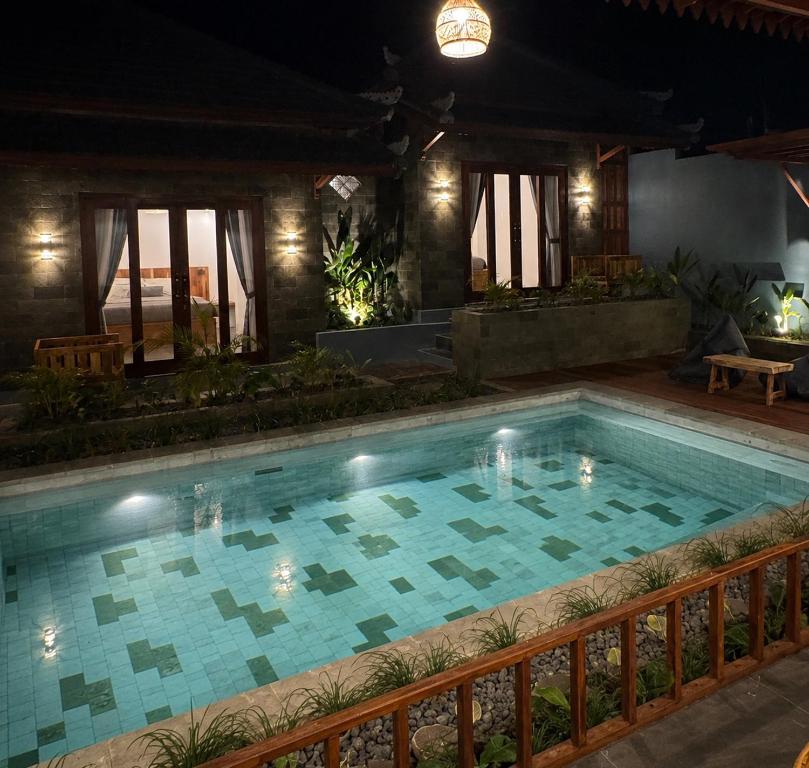 a swimming pool in a house at night at SinCity Nature Private Pool Villa in Tanjung