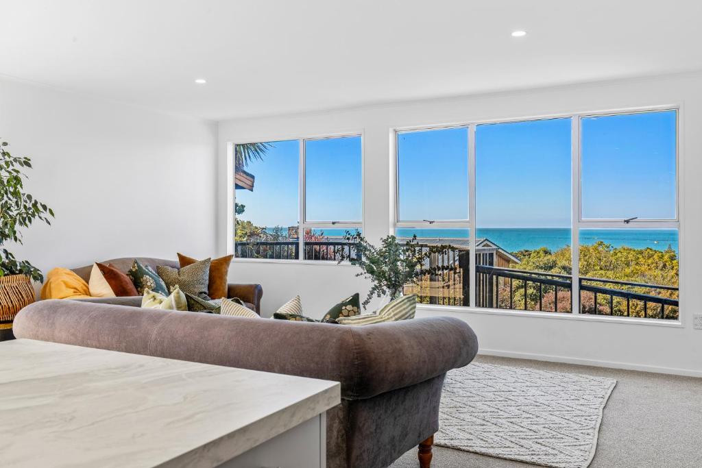 a living room with a couch and a view of the ocean at Ocean Vista Hideaway in Kaikoura