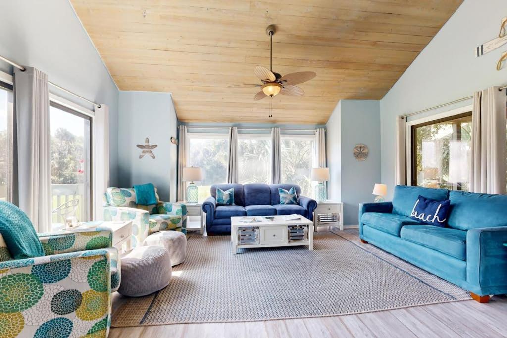 a living room with blue couches and a ceiling fan at Breath'n Easy in Edisto Beach