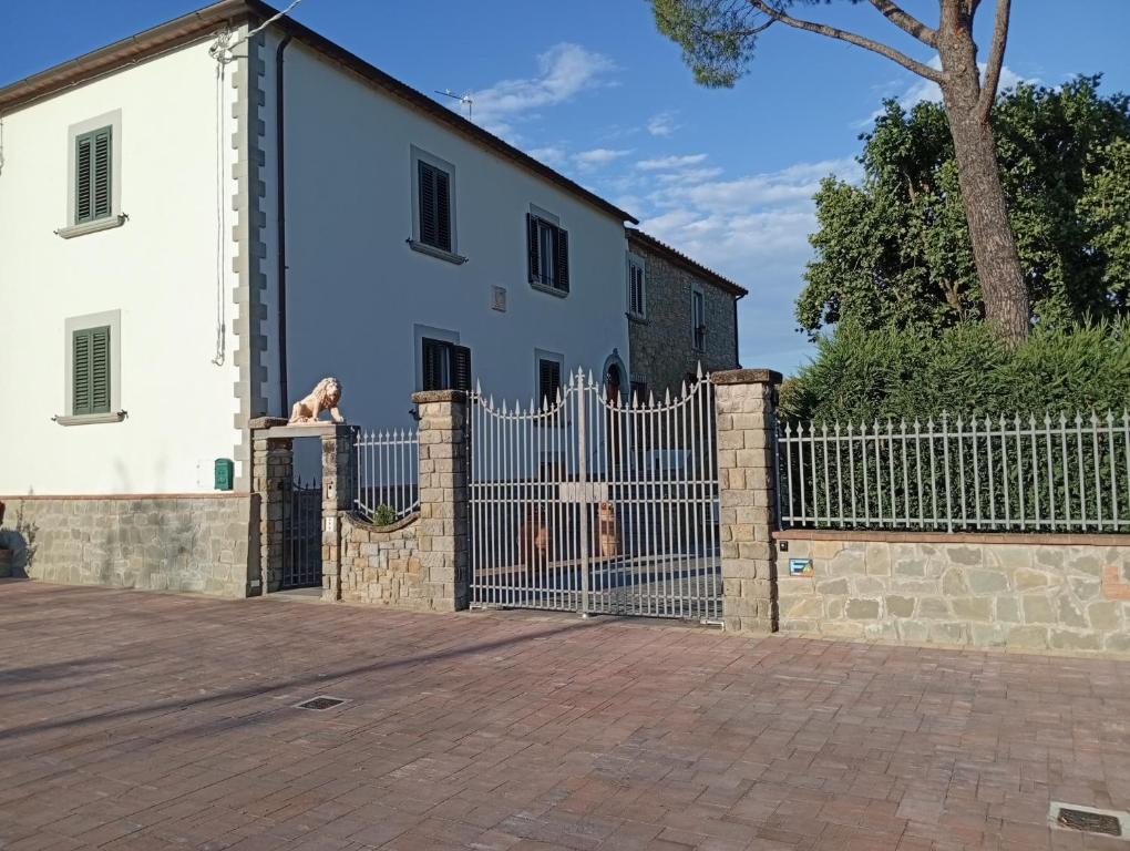a dog looking over a fence in front of a house at I leoni di Montecchio in Castiglion Fiorentino