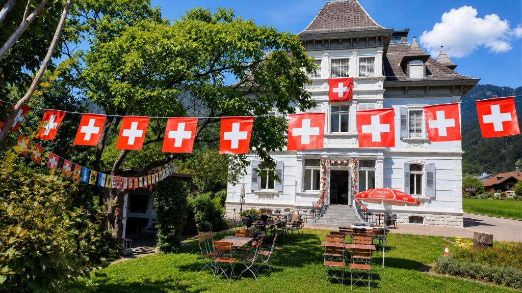 an old house with red and white crosses on it at Adventure Hostel Interlaken in Interlaken