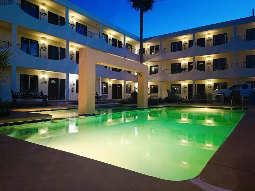 a swimming pool in front of a building at night at Hotel palma de oro in Puerto Peñasco