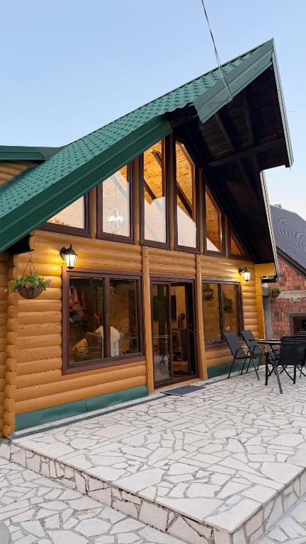 a large wooden house with a stone patio at Mountain Paradise House in Žabljak