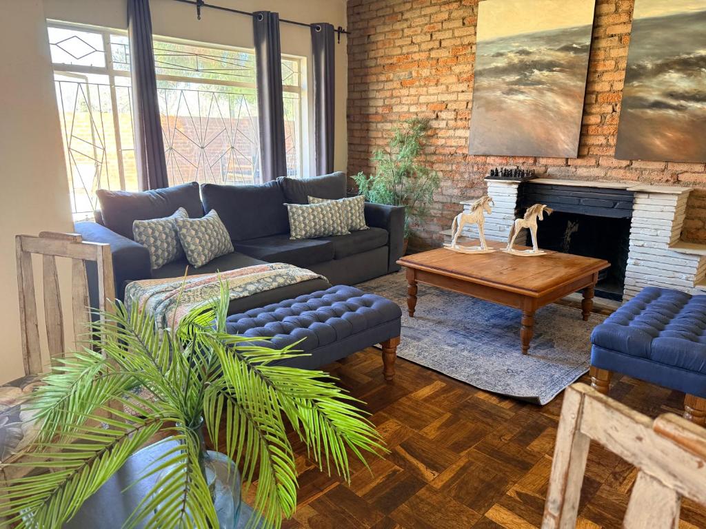 a living room with a couch and a fireplace at Lielies Guesthouse in Parys