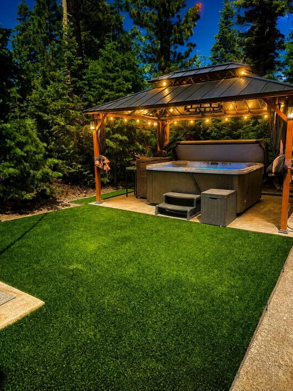 a backyard with a gazebo with a green lawn at Covered Hot Tub Getaway Sleeps 9 in Duck Creek Village