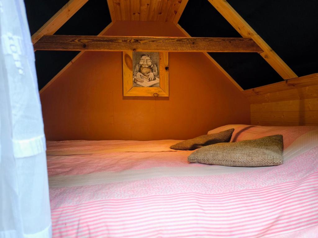 a bed in an attic with a picture on the wall at Sauna Suite 1 in Valga