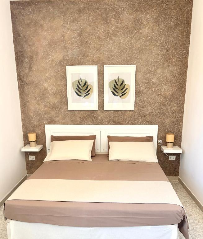 a bedroom with a bed with two pictures on the wall at Casa Salento Diso in Diso