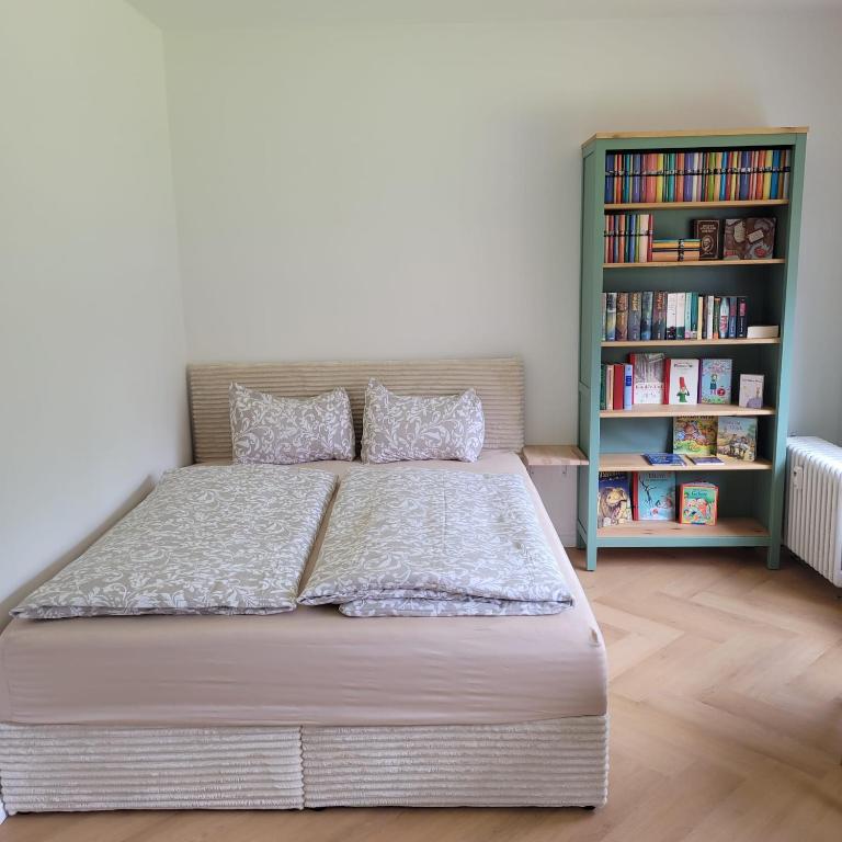 a bedroom with a bed and a book shelf at Ferienwohnung mit Bergblick in Oberammergau