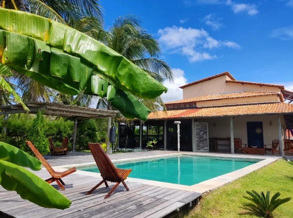 a villa with a swimming pool and a house at Pousada Villa Jodie in Fortim