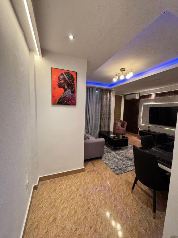 a living room with a couch and a painting on a wall at Chez Charly in Kinshasa