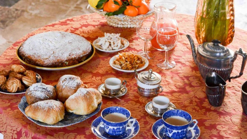 a table topped with plates of pastries and cups of coffee at Casale Rocca Fiorita in Acate