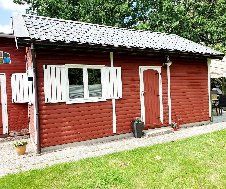 a red shed with a red door and white windows at Zeit für uns in Cuxhaven