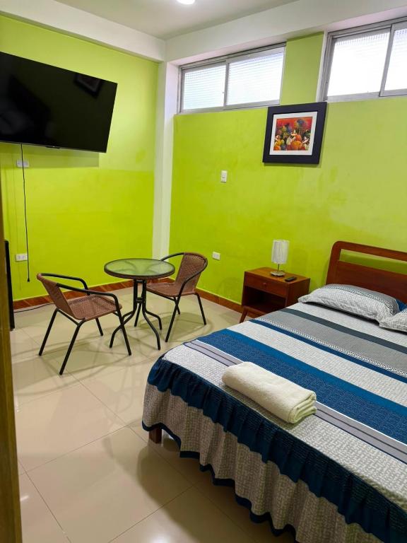 a bedroom with a bed and a table and a tv at JAARR Alojamientos in Pucallpa