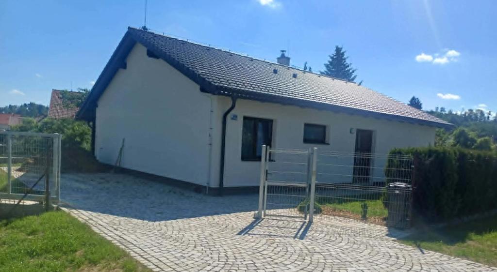 a small white building with a fence in front of it at Rodinný dům Řásná u Telče in Řásná