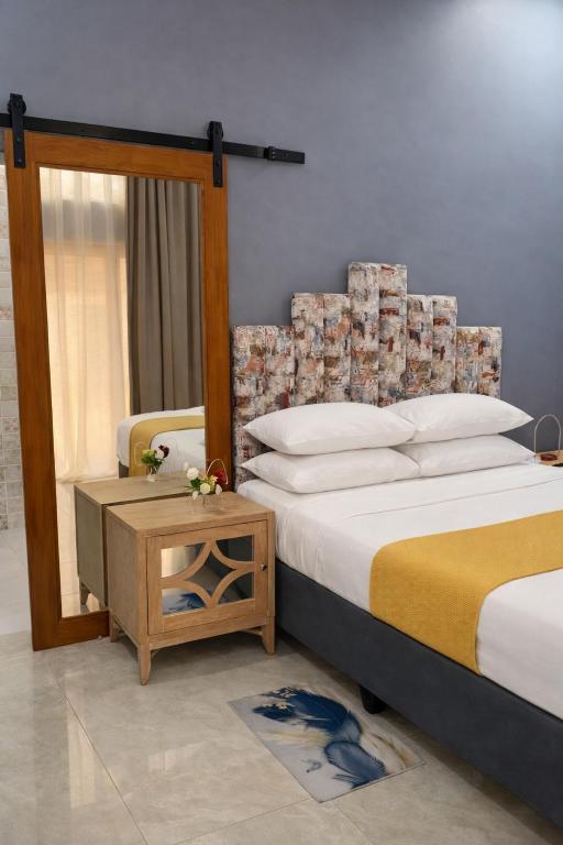 a bedroom with a large bed and a table at Stylish Abode Guesthouse in Palatswe