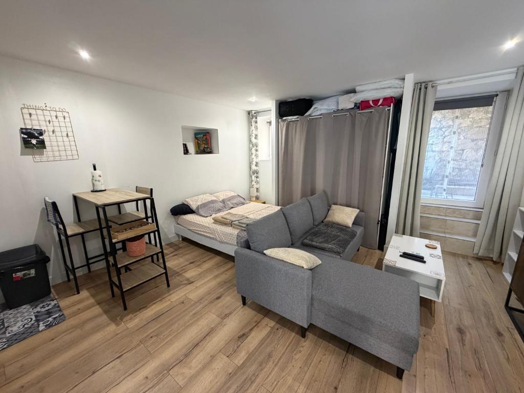 a living room with a couch and a table at Studio centre village in Bocognano