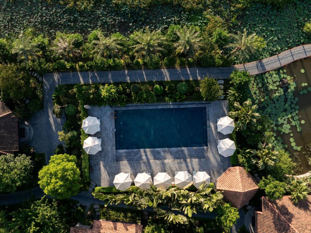 an overhead view of a swimming pool with palm trees at An Hideaway Resort in Ninh Binh