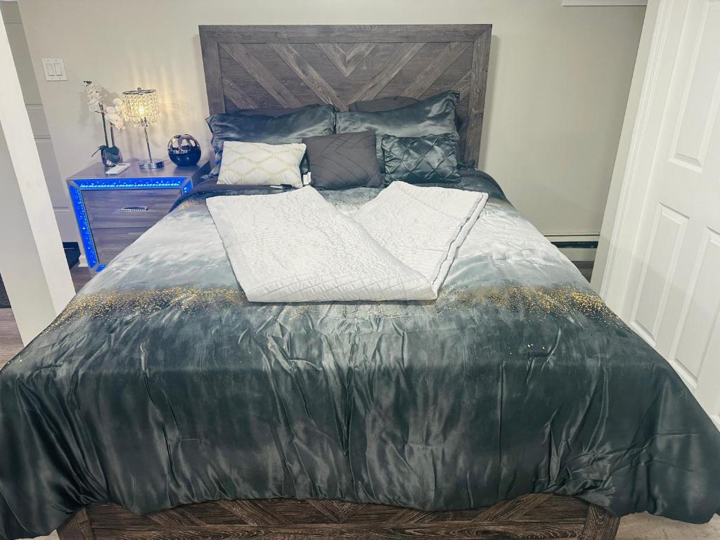 a bedroom with a large bed with a wooden headboard at Elmont Escape Studio in Elmont