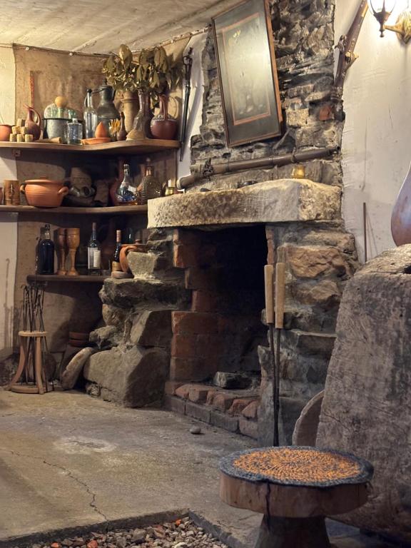 a stone fireplace with a tv on top of it at Eco-friendly Guesthouse Tea Gezruli 25 km from Chiatura in Tsinsopʼeli