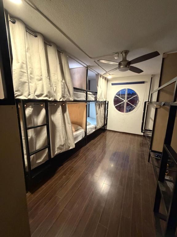 a room with two bunk beds and a ceiling fan at Hostal Vibes in Oaxaca City