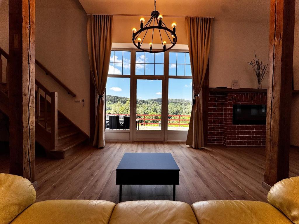 a living room with a couch and a large window at Apartmán U Medvěda in Vejprty