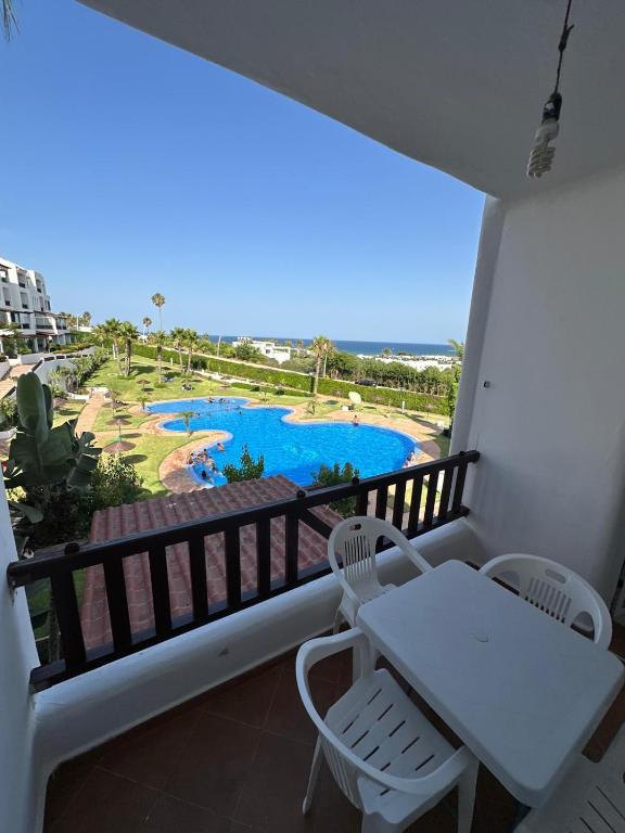 a balcony with a table and chairs and a pool at Excelente apartamento en Cabo beach in Cabo Negro