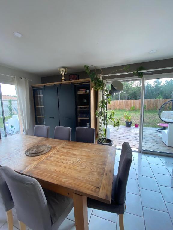 a dining room with a wooden table and chairs at Villa Cazaux in La Teste-de-Buch