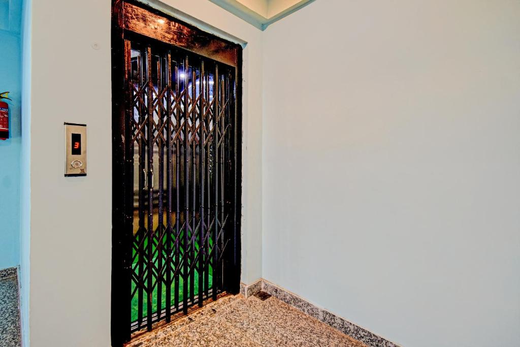 a black door with a metal gate on a wall at Hotel O Casa Astra in Salua