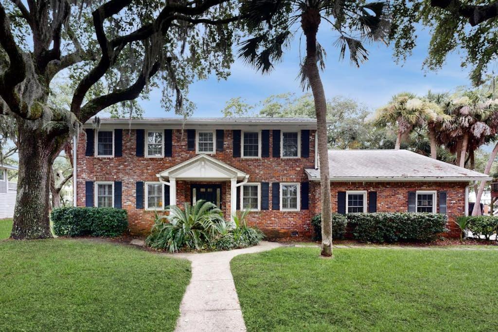 a brick house with palm trees in front of it at Meant To Beach in Edisto Beach