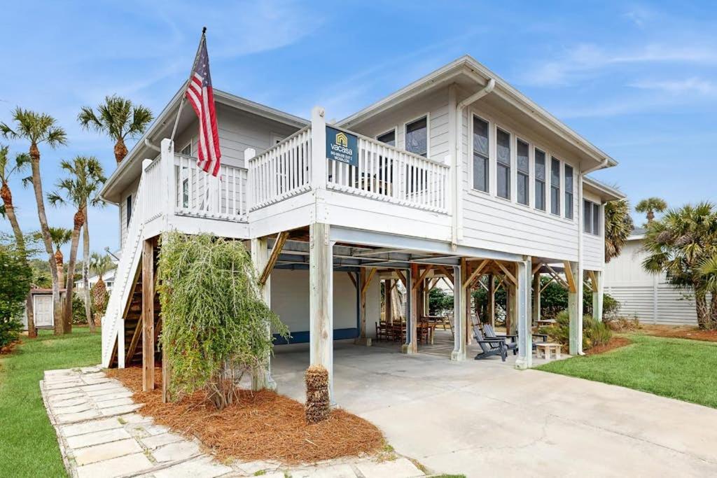 a white house with a porch and a flag at The Answer in Edisto Island