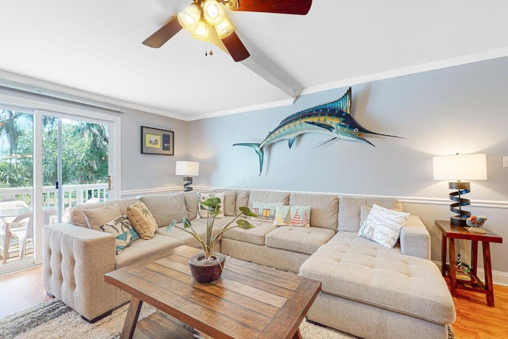 a living room with a couch and a table at Driftwood Villa - 262 in Edisto Beach