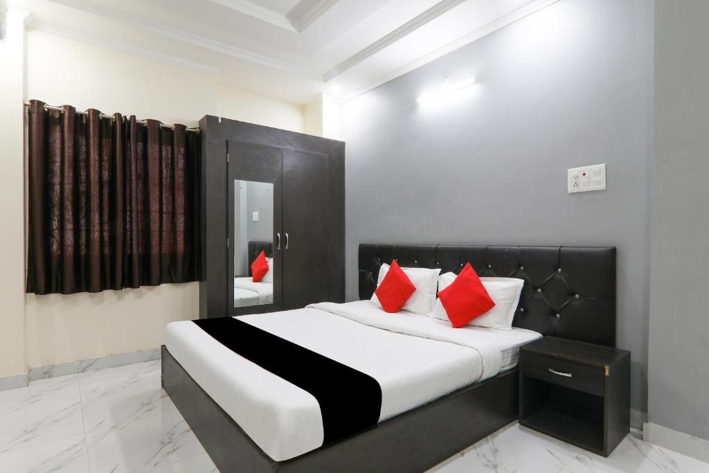 a bedroom with a large bed with red pillows at Hotel O Figtree Premier in Patna