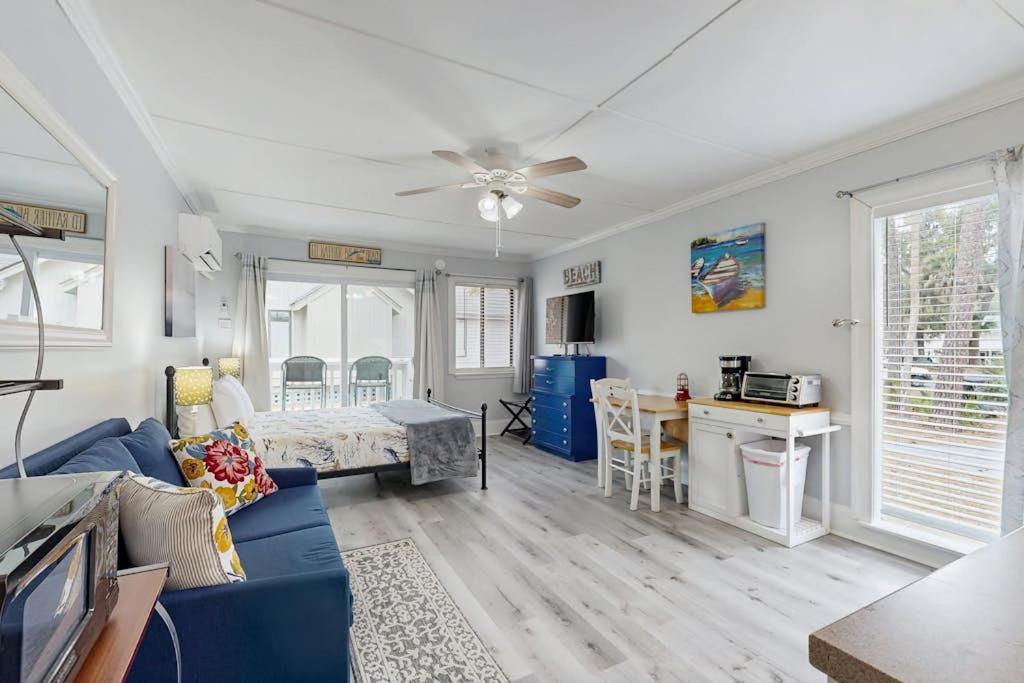 a living room with a blue couch and a ceiling fan at Sea La Vie in Edisto Island