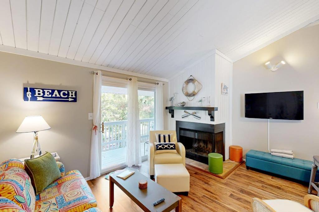 a living room with a couch and a fireplace at Driftwood Villa - 267 in Edisto Island