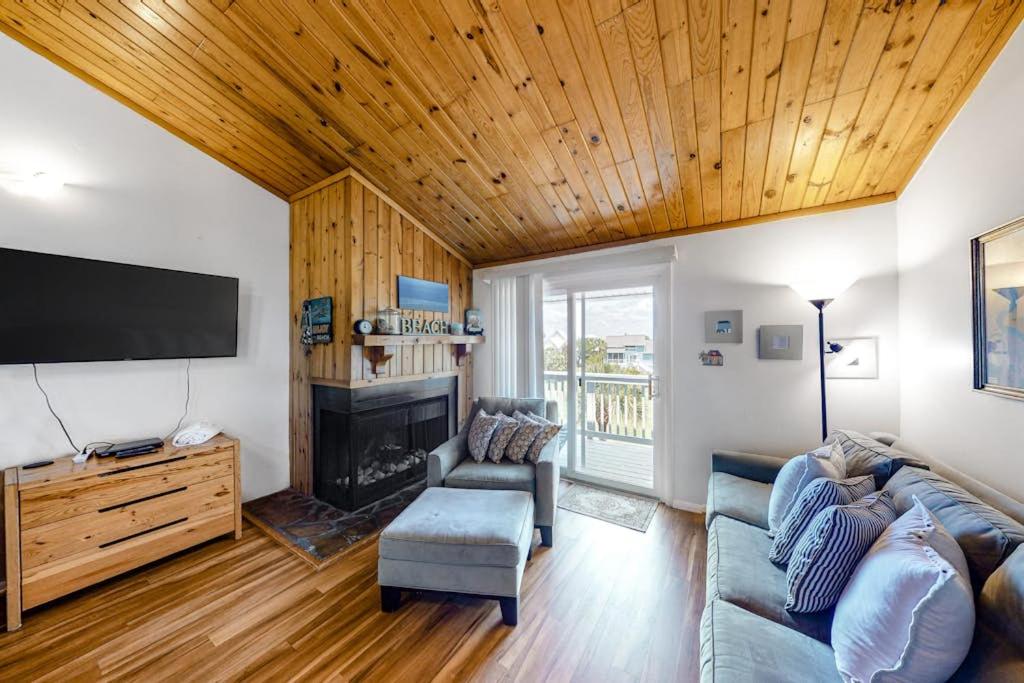 a living room with a couch and a tv at Driftwood Villa - 259 in Edisto Beach