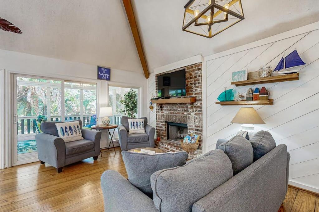 a living room with a couch and chairs and a fireplace at Artsea Phartsea in Edisto Beach