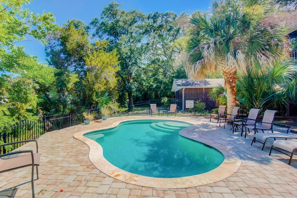 a swimming pool with chairs and a patio at Goldie's Retreat in Edisto Beach
