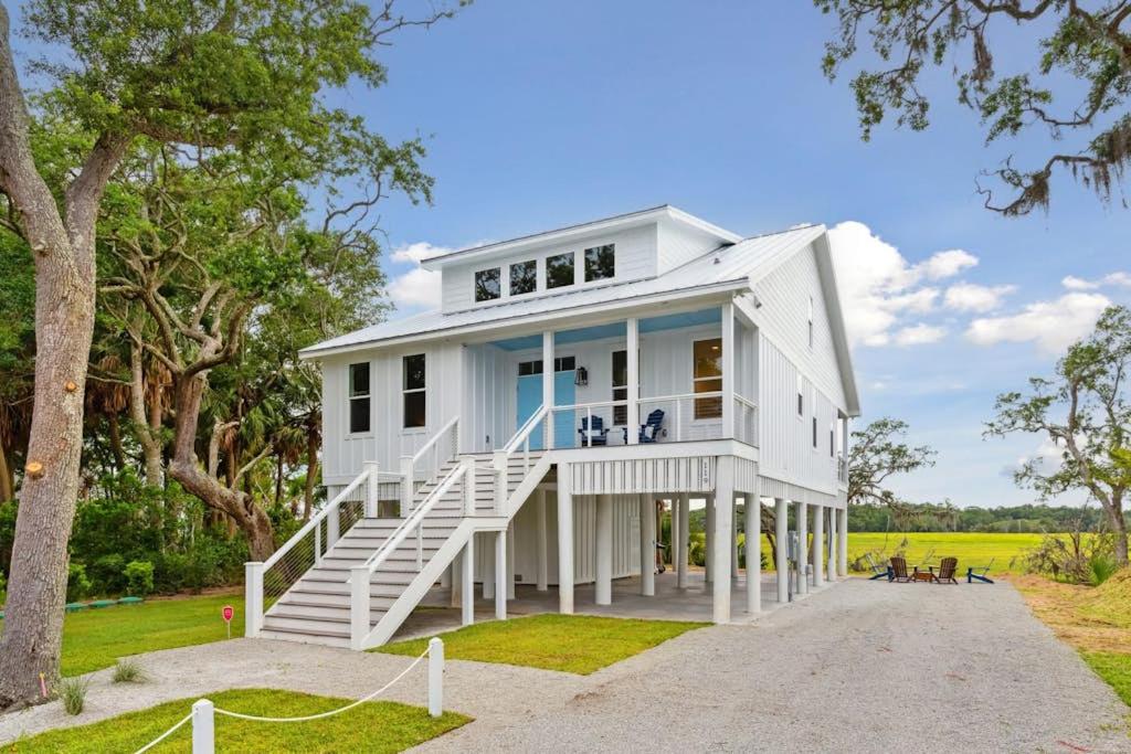 a white house with a porch and stairs at Champagne and Sunsets in Edisto Island
