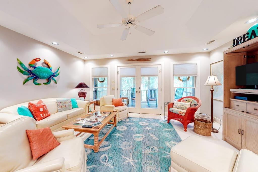 a living room with a white couch and a table at Slow Drift in Edisto Beach
