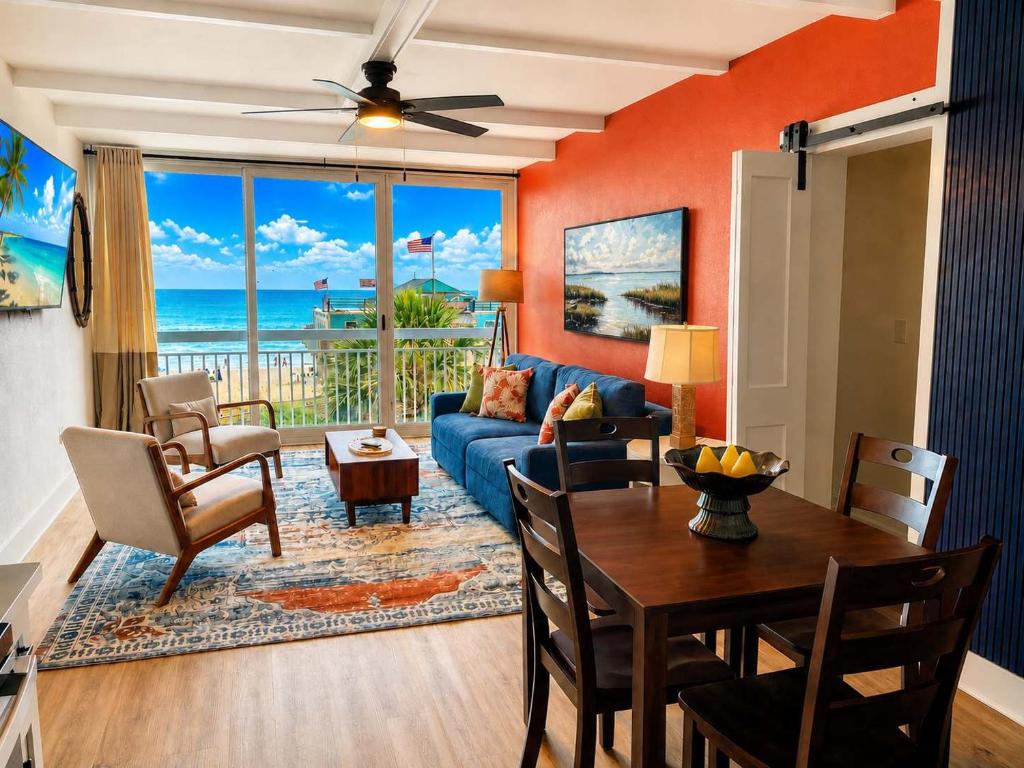 a living room with a blue couch and a table at Renovated Oceanfront 1BR by Skywheel Yachtsman 400 in Myrtle Beach