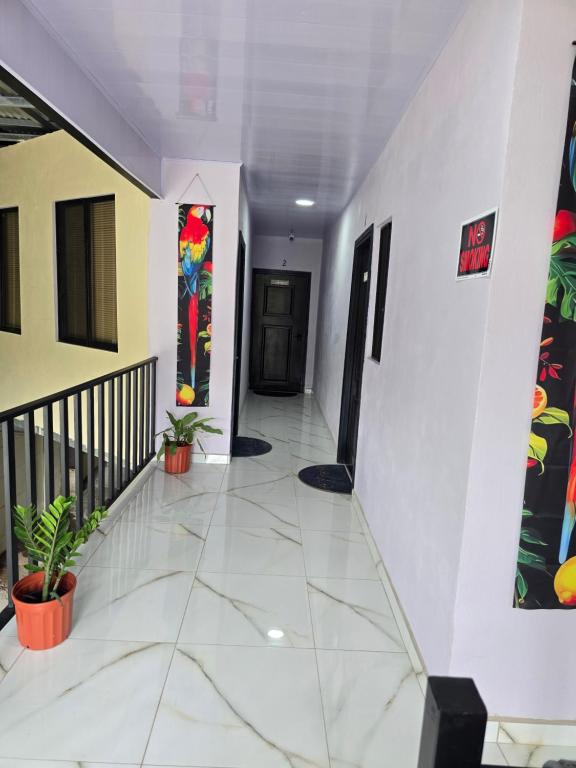 a hallway with a white tile floor and a staircase at Apartamentos Torres Manuel Antonio in Manuel Antonio