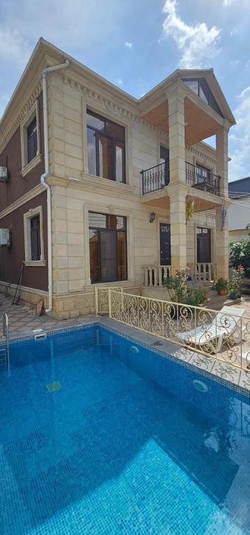 a house with a swimming pool in front of a house at Riverside Villa GDR in Gabala