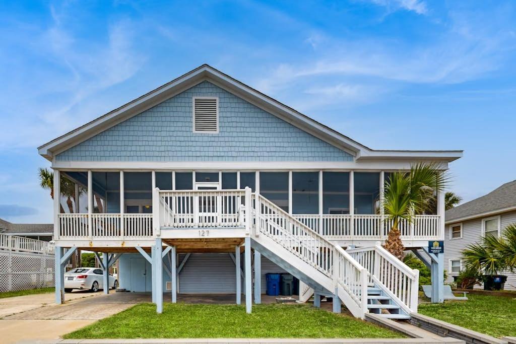 a large house with a porch and white railings at Myra's Cottage in Edisto Beach