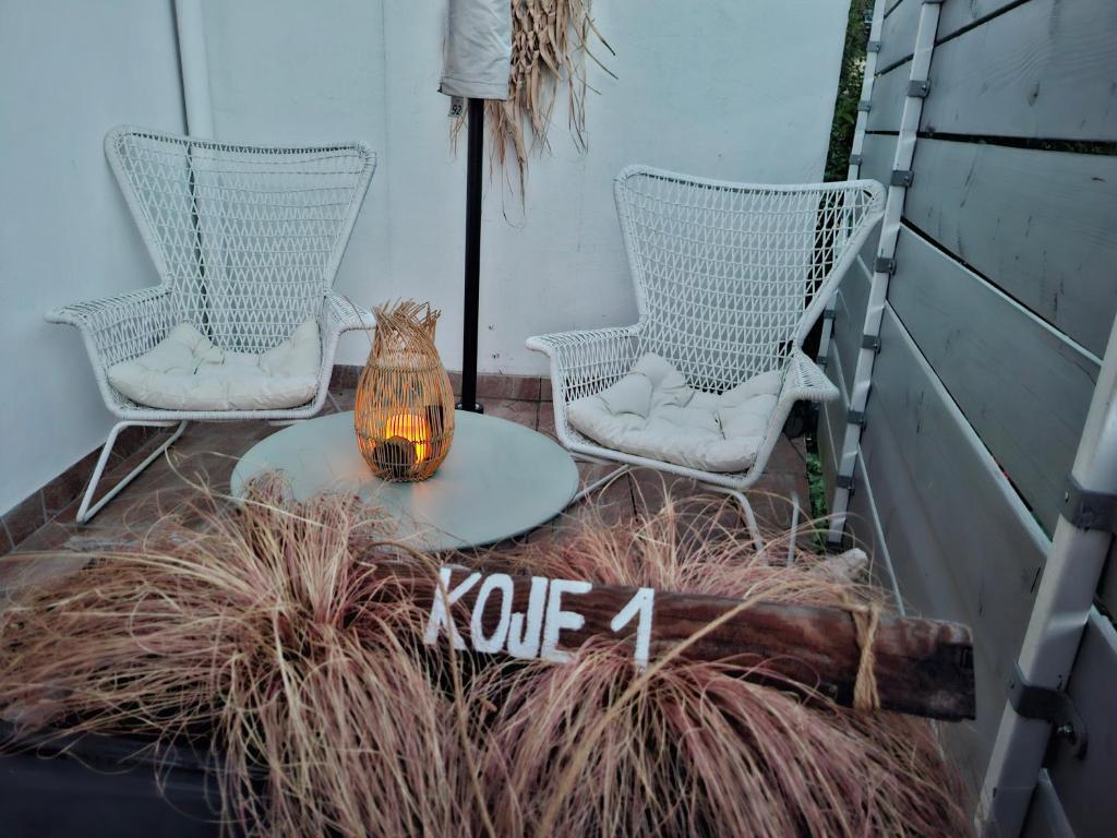 two chairs and a table with a vase on a patio at Koje1 in Bremm