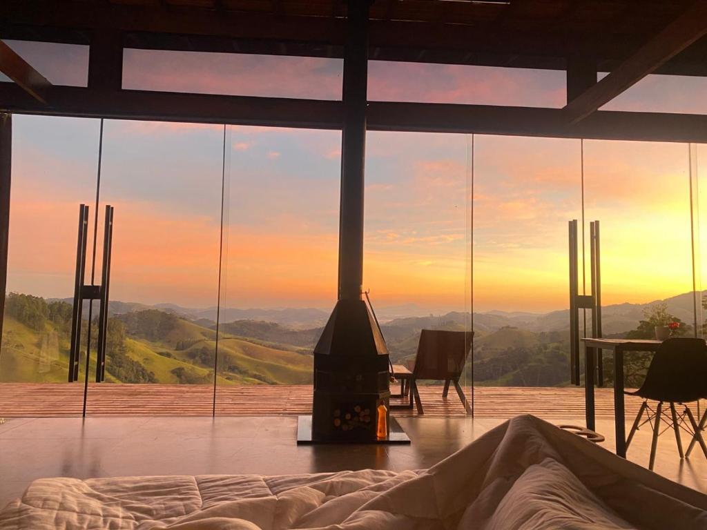 a fireplace in a bedroom with a view of the mountains at Shangri-lá Chalés in Gonçalves