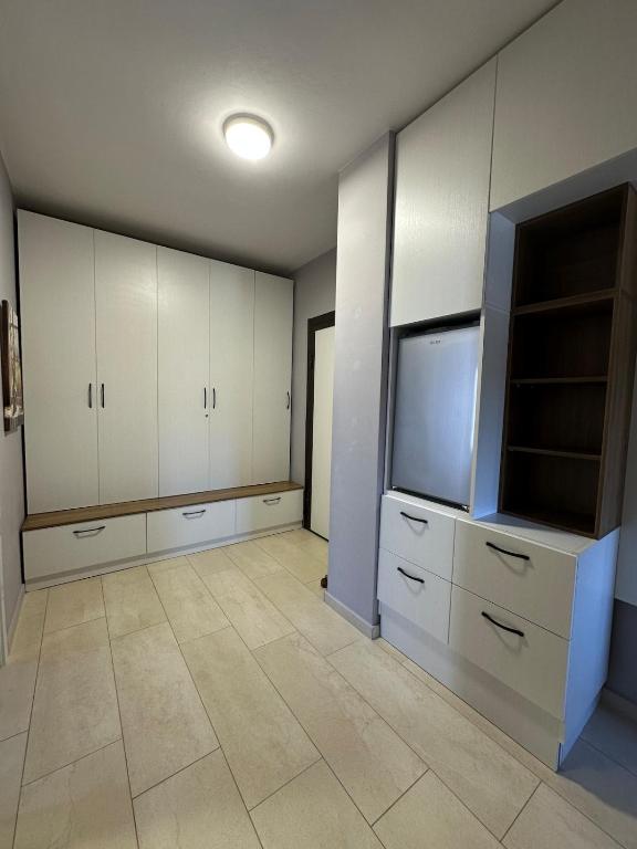 a large room with a tv and white cabinets at River apartment in Tushemisht