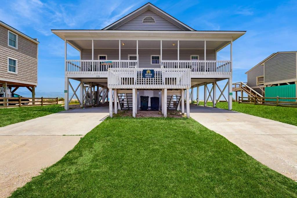 a large house with a large deck on the grass at A Shore Thing in Edisto Beach